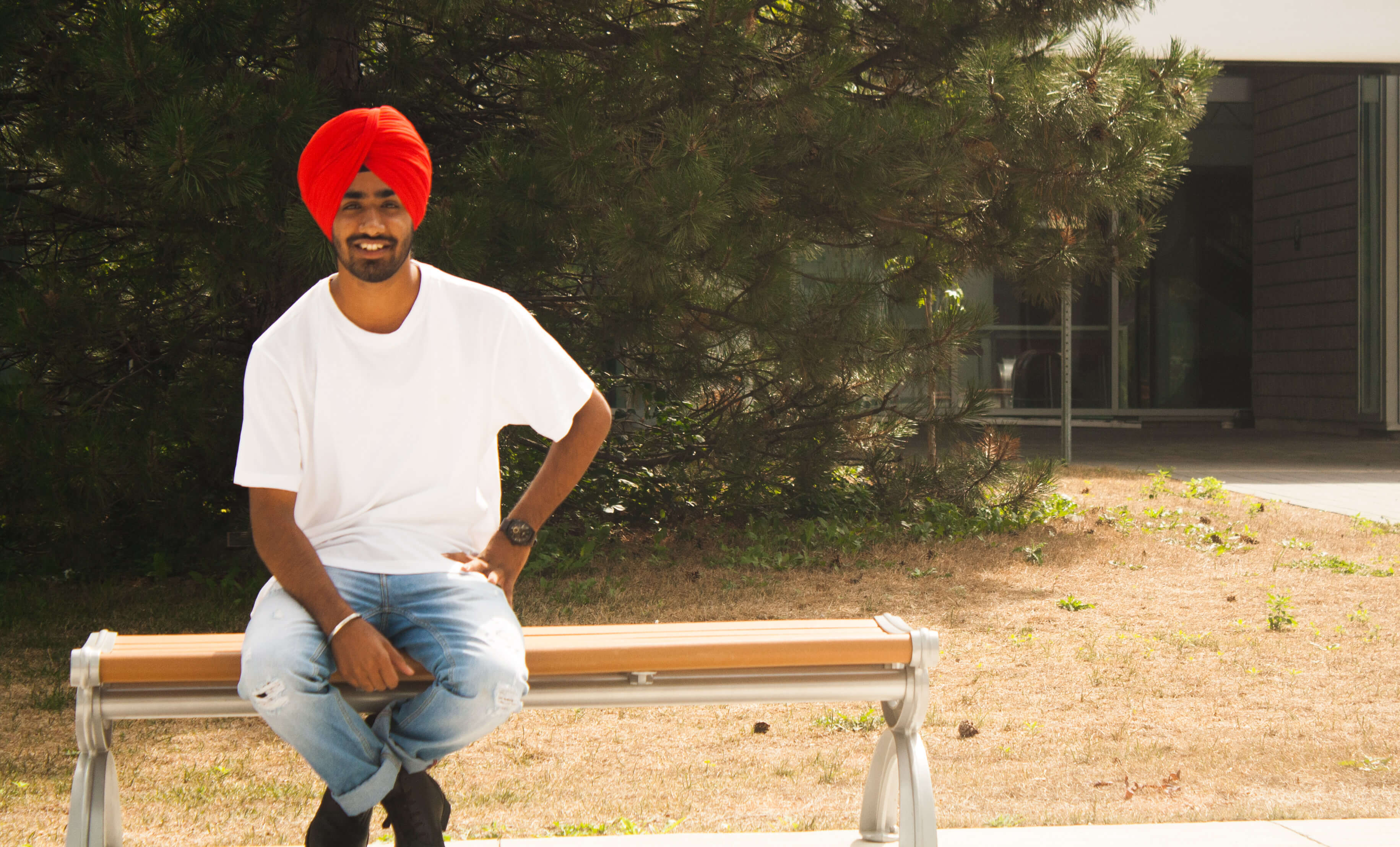 Gurjot wearing White T-Shirt Bleached Jeans Red Turban and Dark Leather Boots