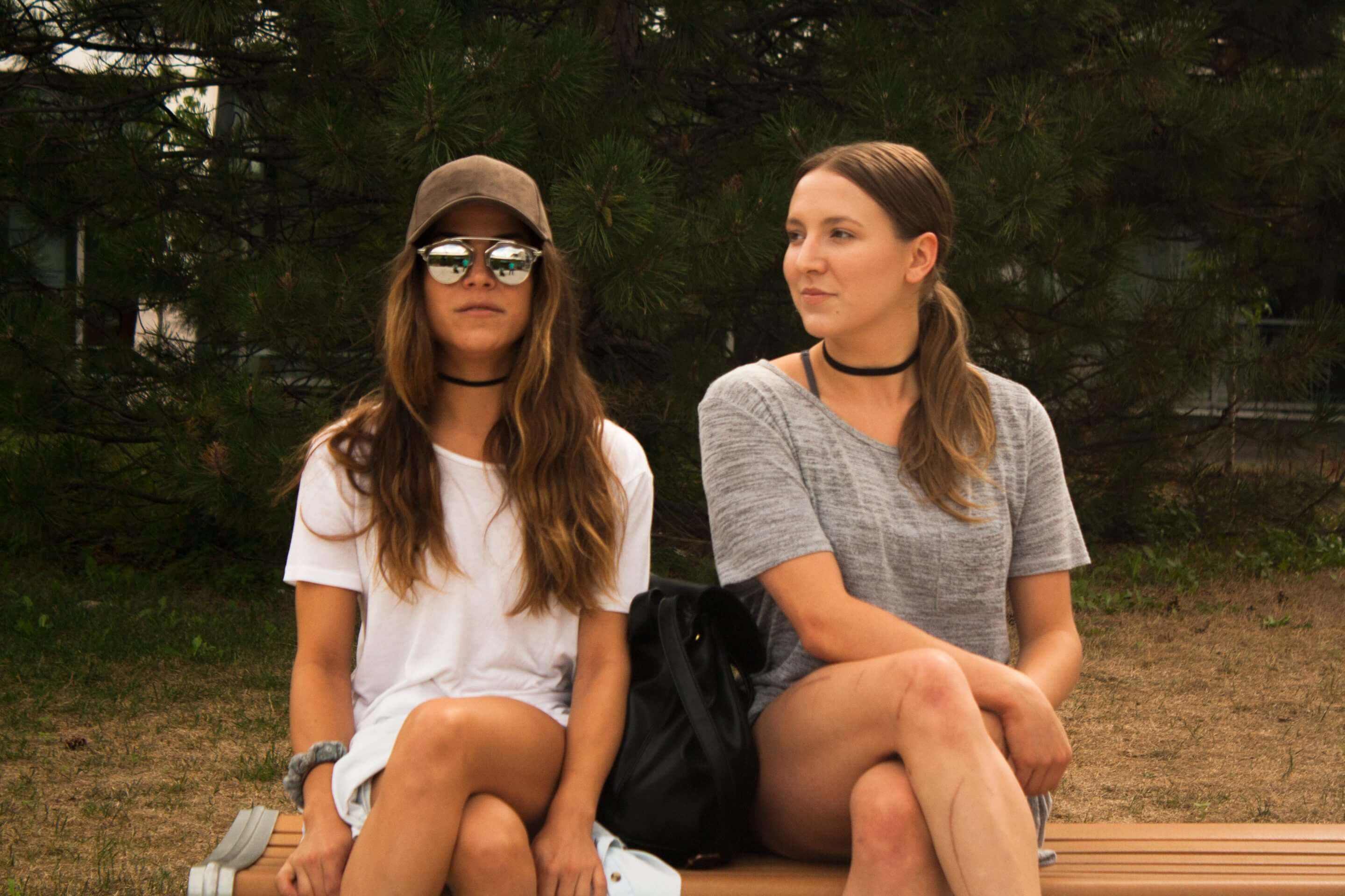 Dayna in Reflective Aviators, Brown Baseball Cap, Black Choker and White Blouse, Josee in Grey Blouse and Black Choker