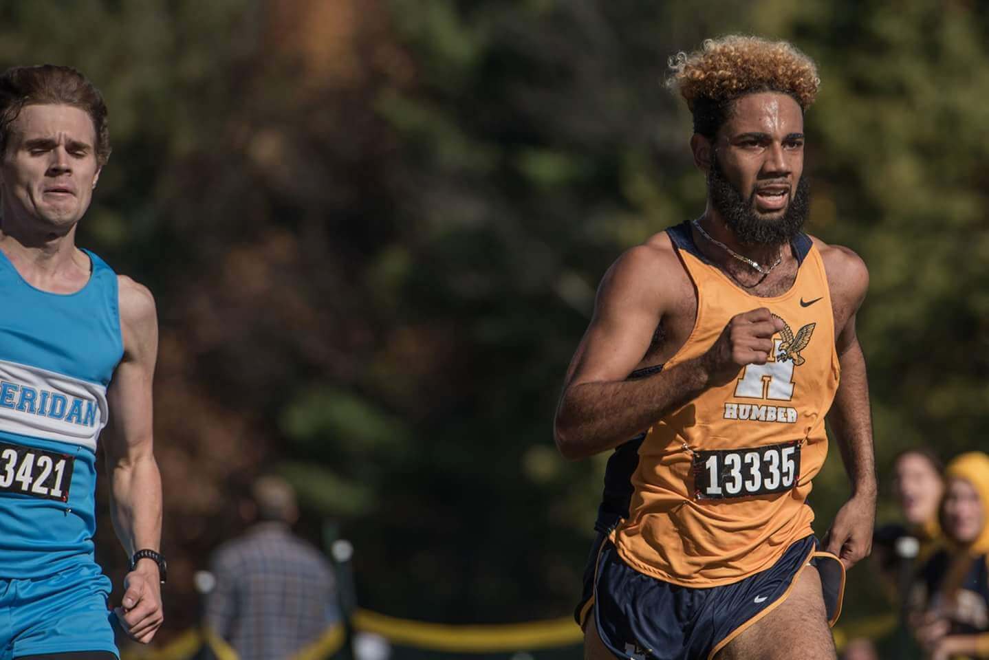 Jake Thomson racing beside a runner from Sheridan College