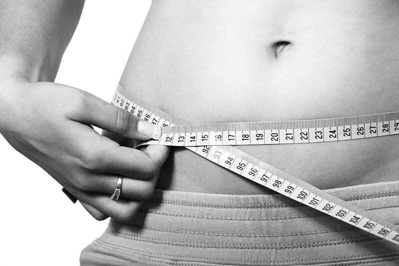 girl taking measuring tape to her waist