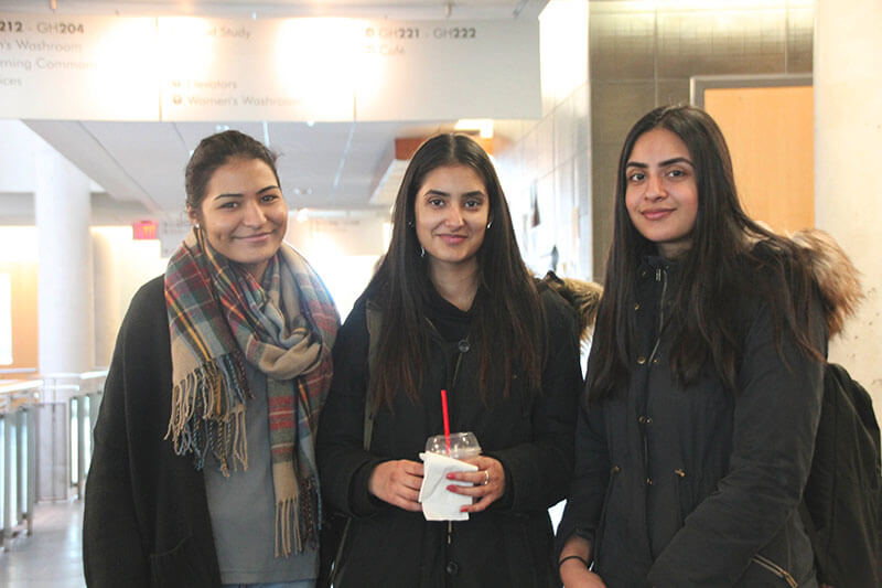 Three students in winter coats stand together in Guelph-Humber.