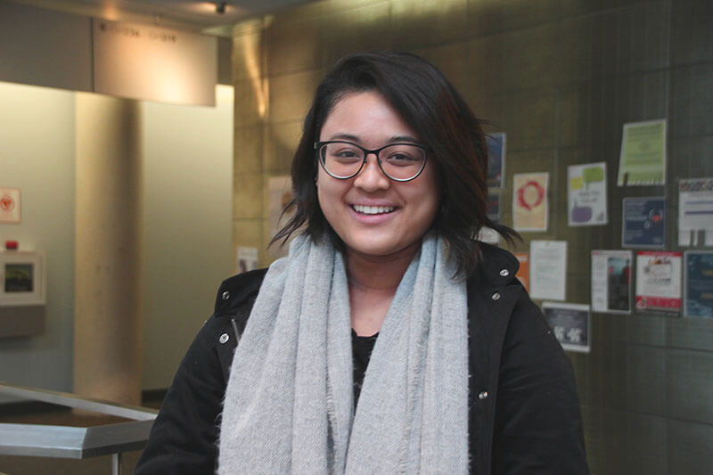 Student smiling in Guelph-Humber spiral stairs.