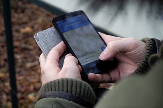 Person holding phone in hands, map on screen