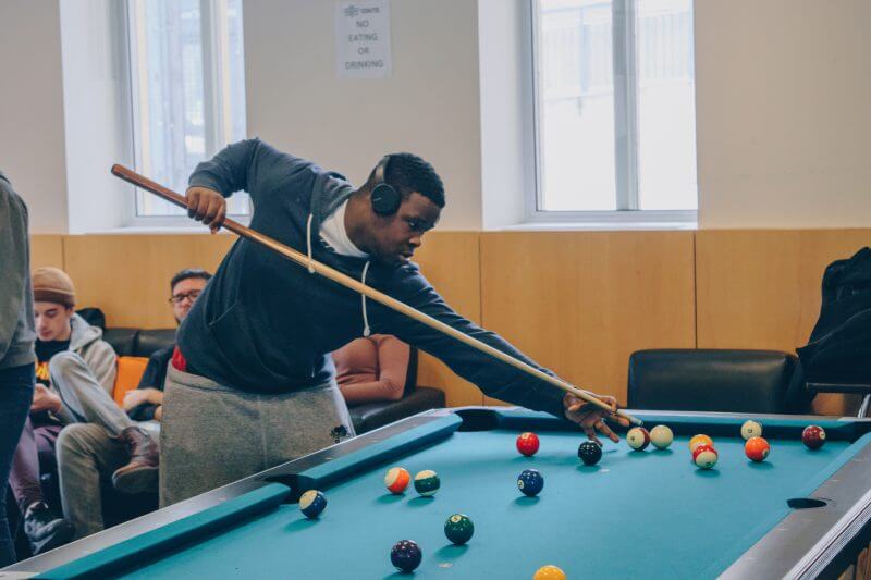 Johnoi Montaque taking a pool shot.