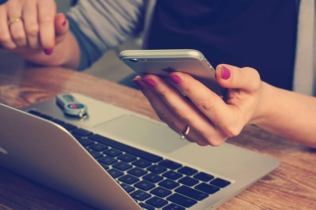 Person holding phone at desk