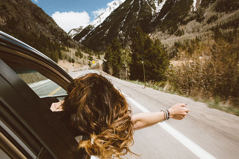 Girl sticking head out of car