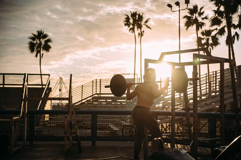 Man squatting at gym outside