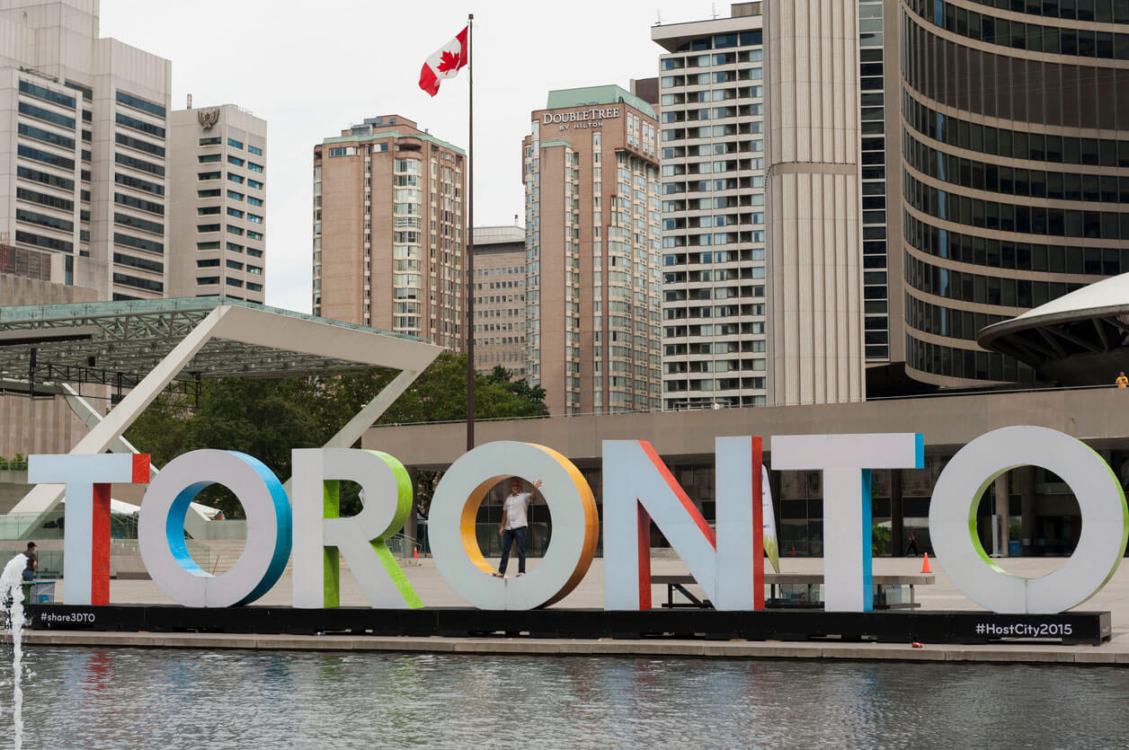 Man standing inside of Toronto Sign