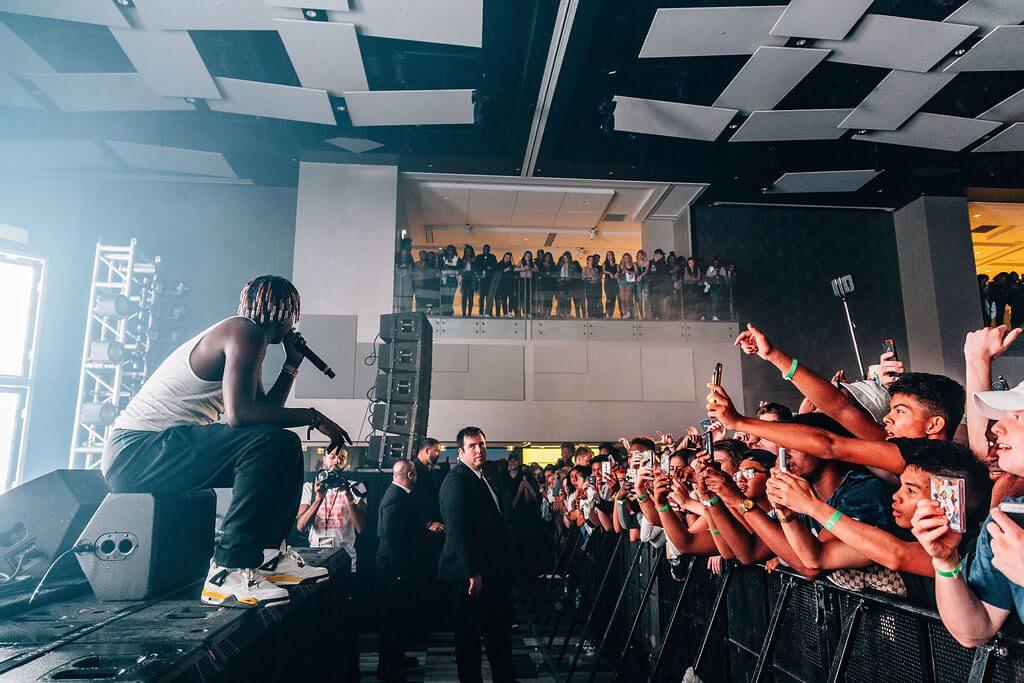 Lil Yachty sitting on stage in front of crowd