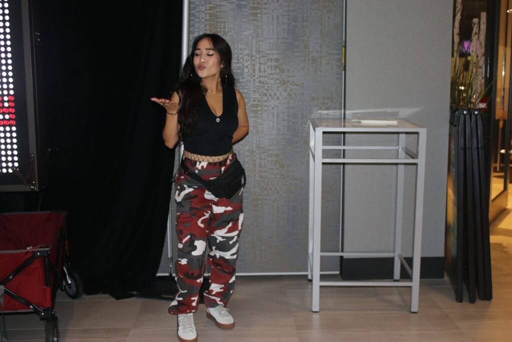 Girl with black tank top and red camouflage pants
