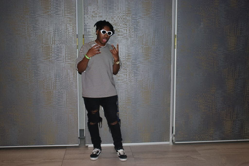 Guy with white sunglasses striped shirt and black ripped jeans