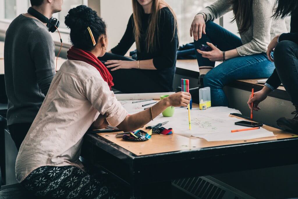 A group of students sitting around a table with papers and highlighters