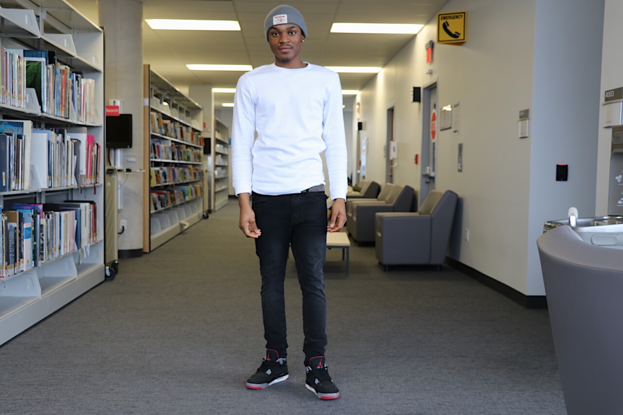 Man wearing thermal shirt, hat, jeans and Jordan shoes.