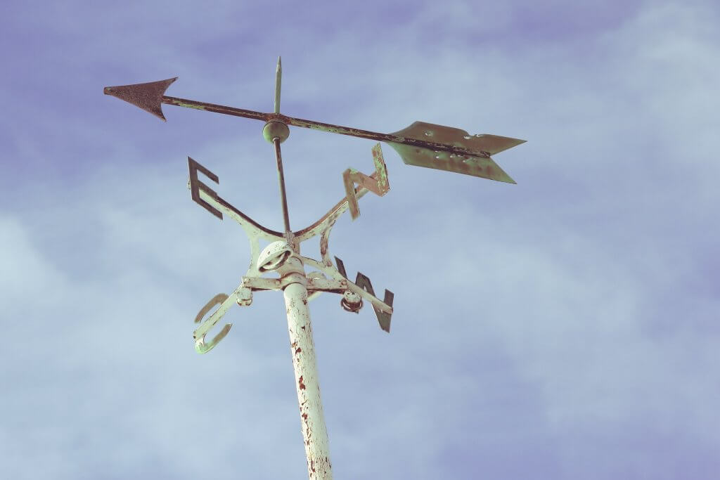 white weather vane against blue sky 