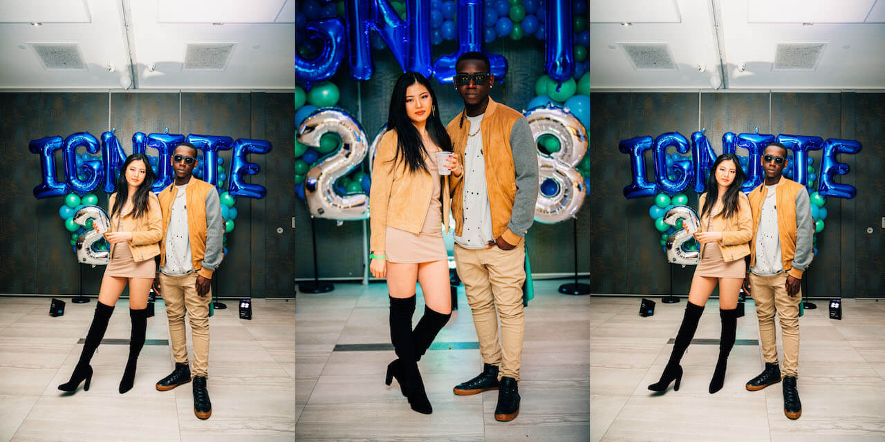 A male wearing pants and a light jacket and female wearing a dress pose for a photo at Frost 2018