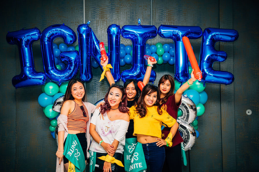 Group of girls pose in front of IGNITE balloons
