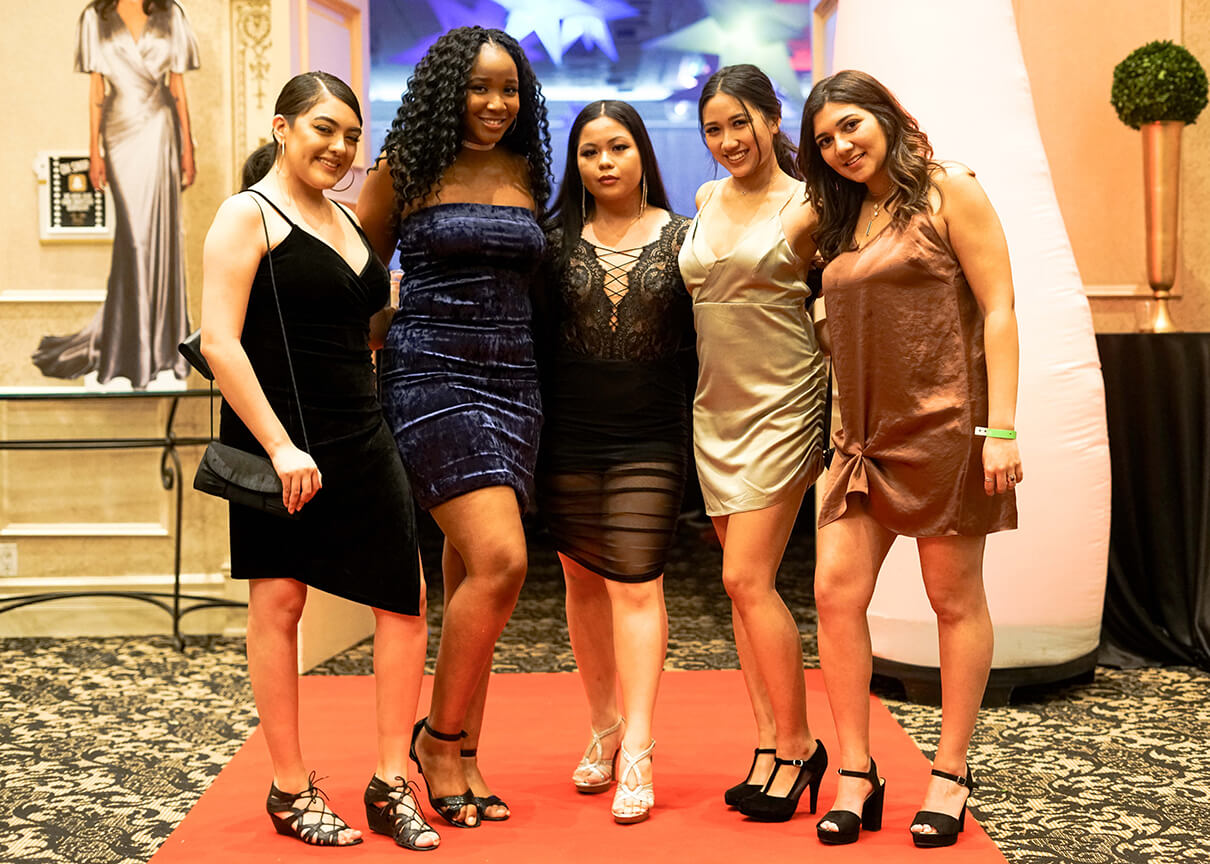 5 girls smiling, in dresses, pose at Gala