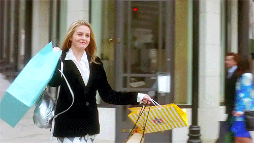 lady leaving a store holding up her shopping bags