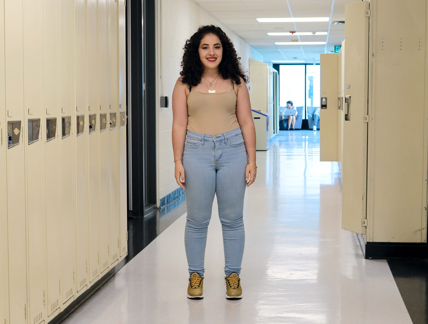 Student poses in hallway near lockers