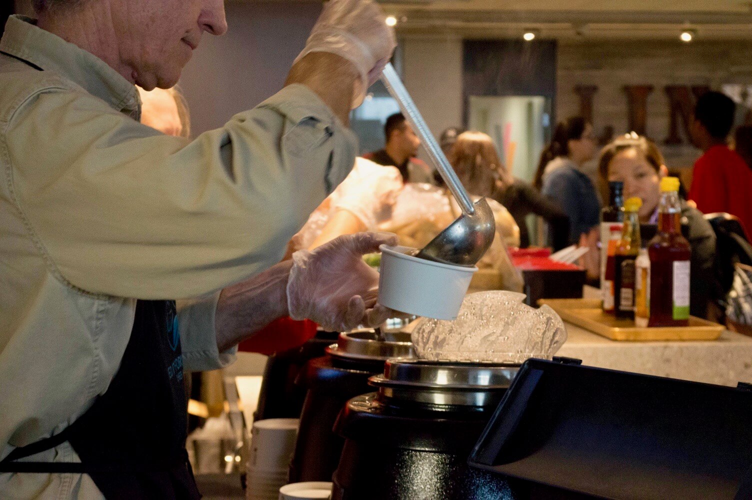 man serving soup into a bowl