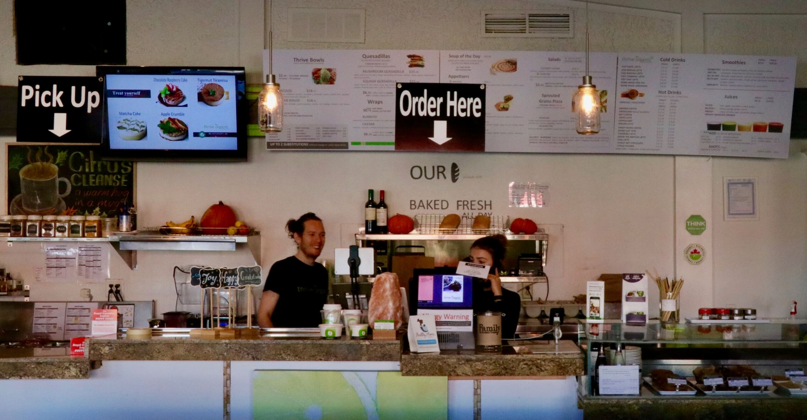 Front counter with menu and cashiers at Thrive Organic restaurant on Lake Shore.