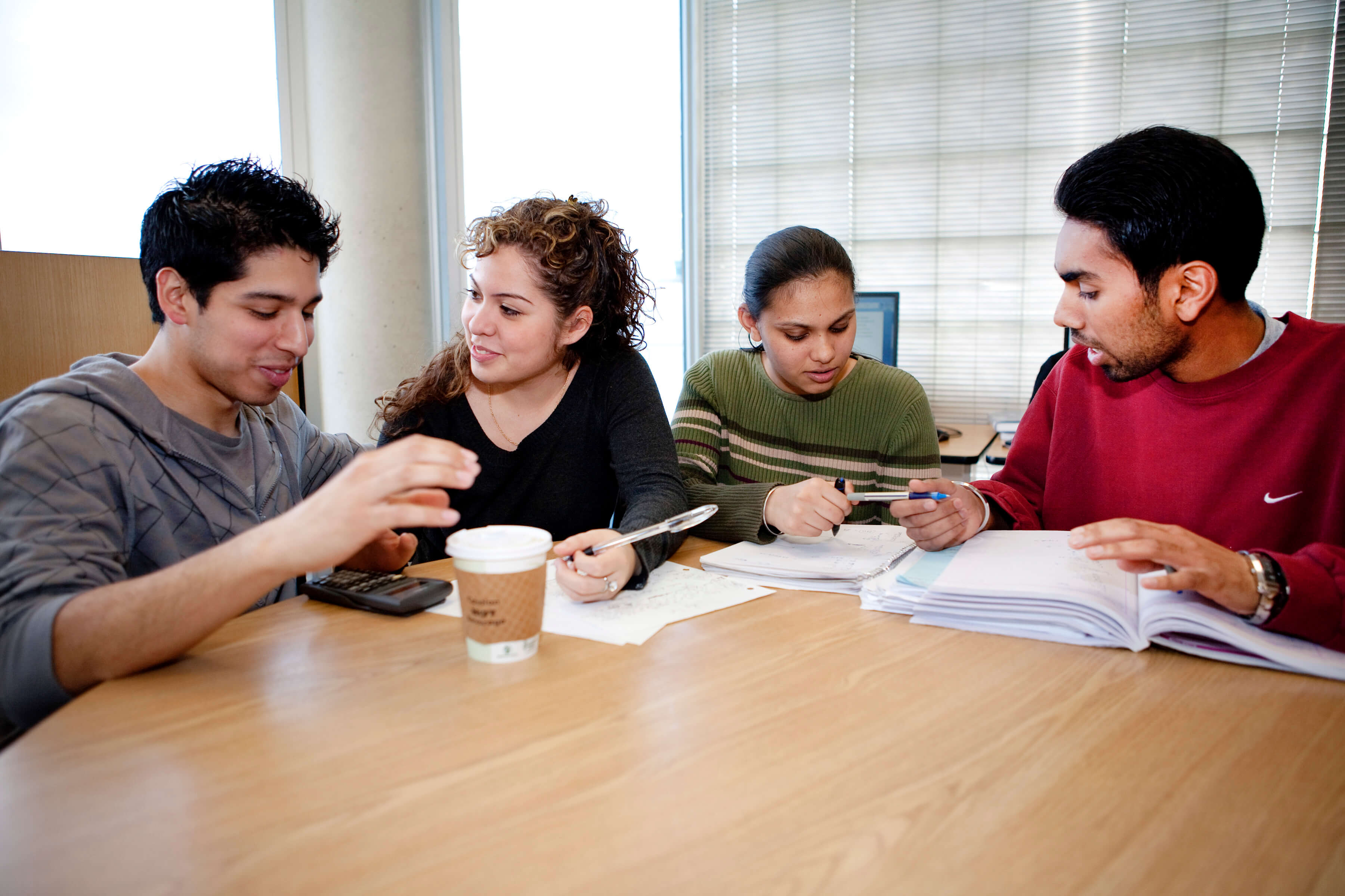 two people sitting together with notebooks open in front of them