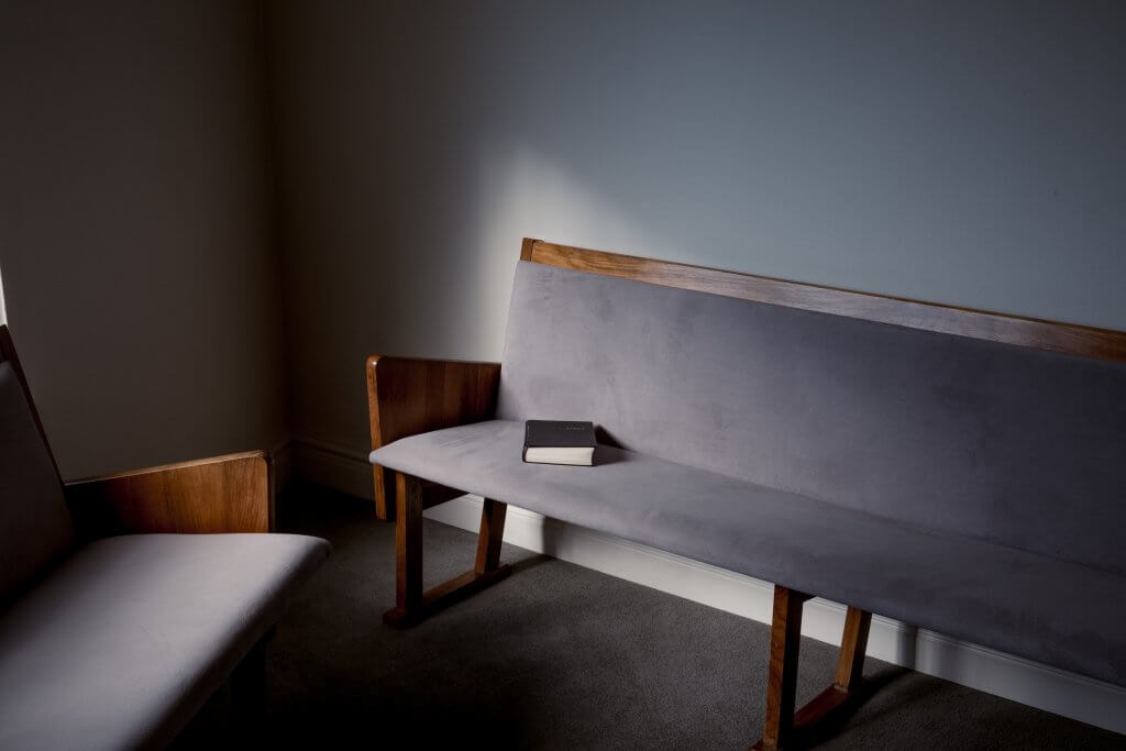 Two suede benches in a room with a book resting on one of them.