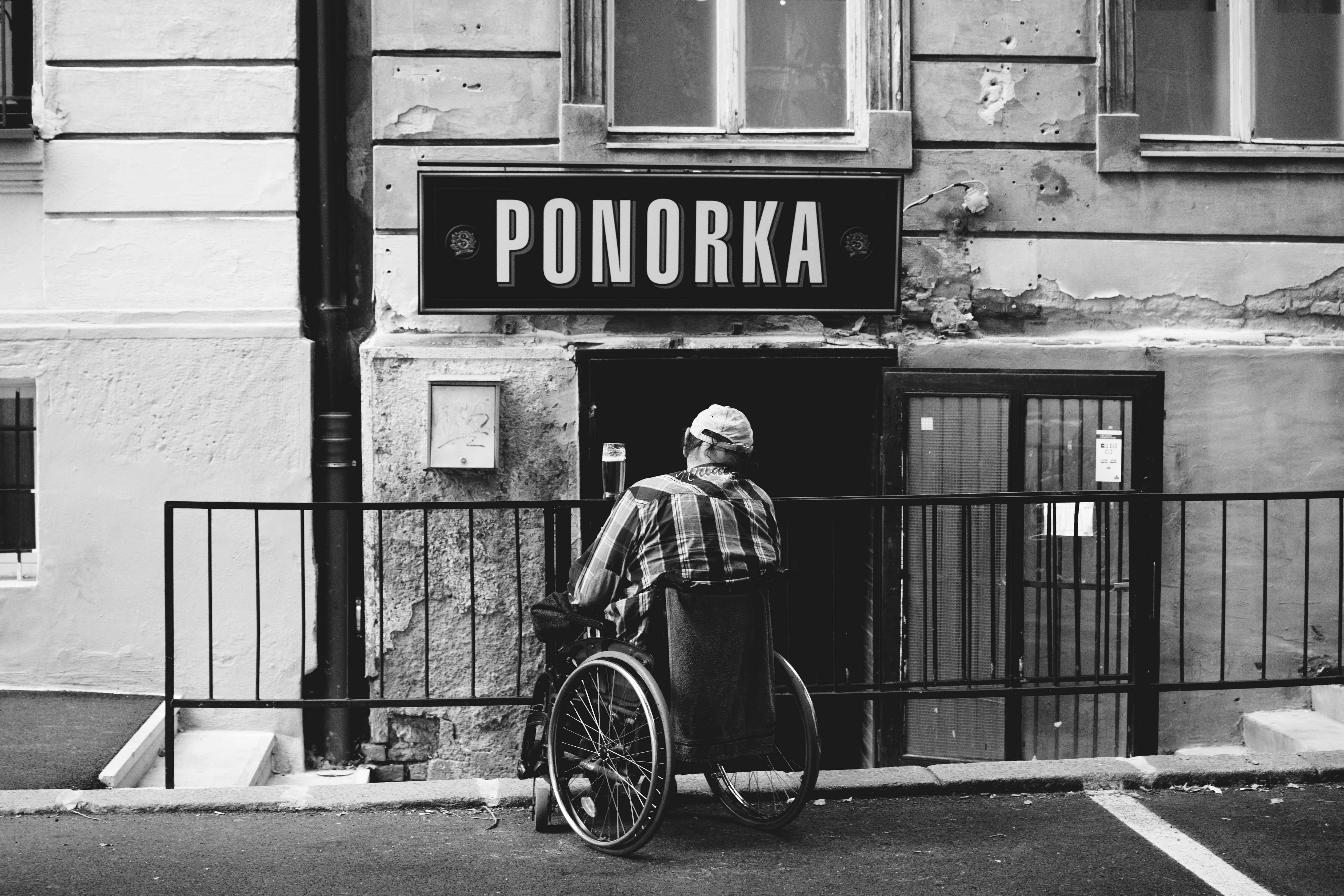 man in a wheelchair sitting in front of a flight of stairs