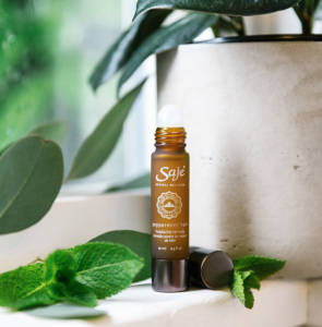 Saje peppermint halo roll on surrounded by mint leaves
