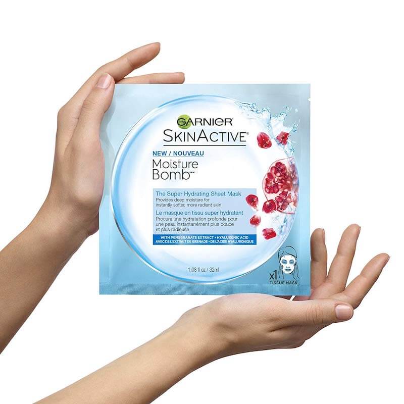 Hands holding packet of Garnier Skin Active Moisture Bomb Mask