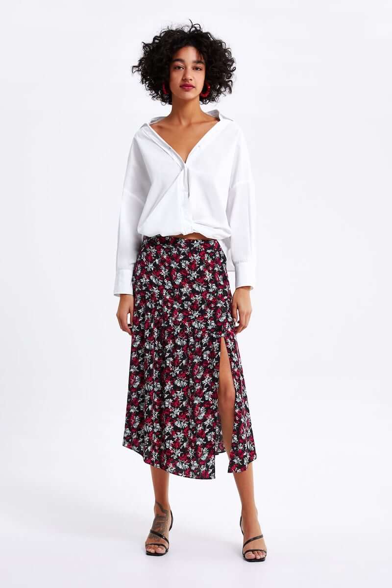 Woman wearing white top and floral, below-the-knee shirt