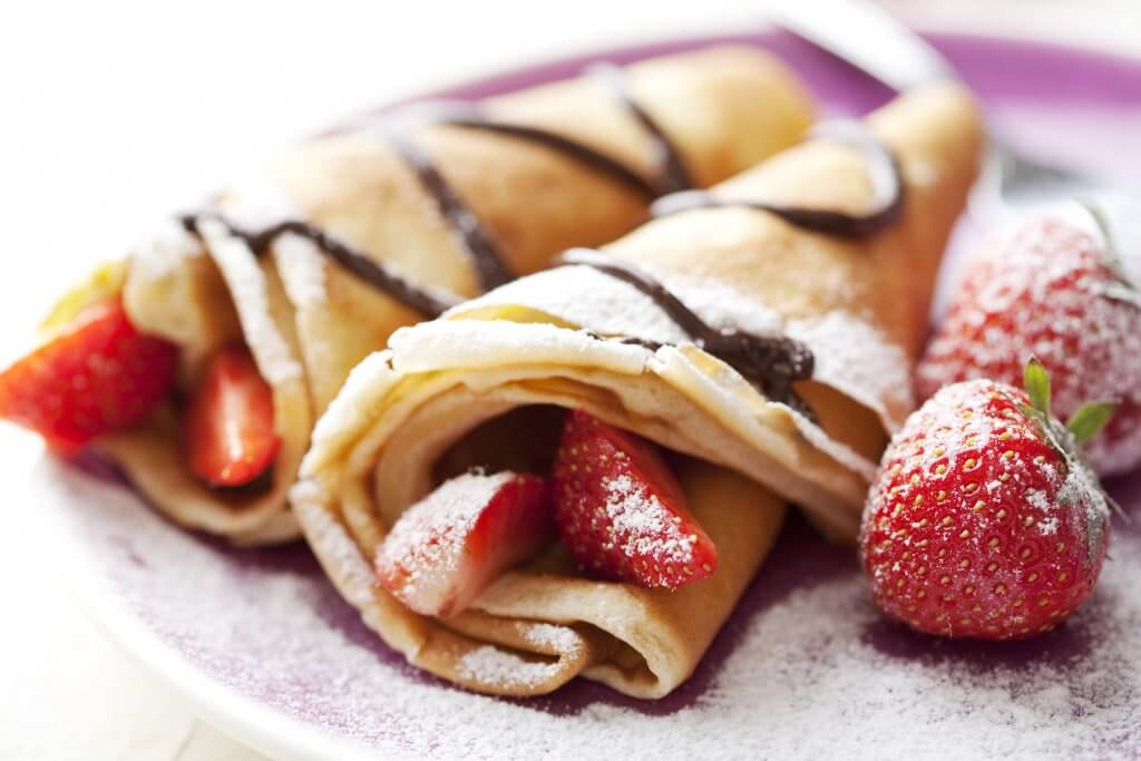 close up of two french style crepes.Some ingredients in the background