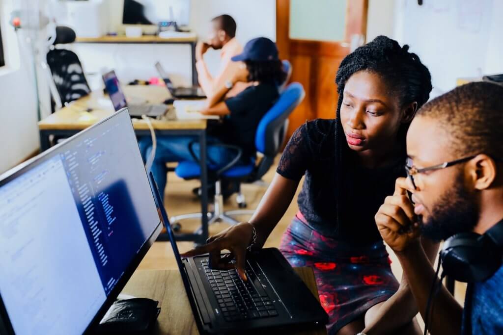 Woman and man sitting in front of screens