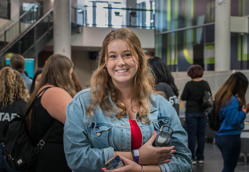 girl smiling and wearing jean jacket