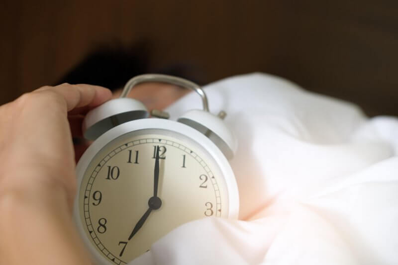 hand holding alarm clock