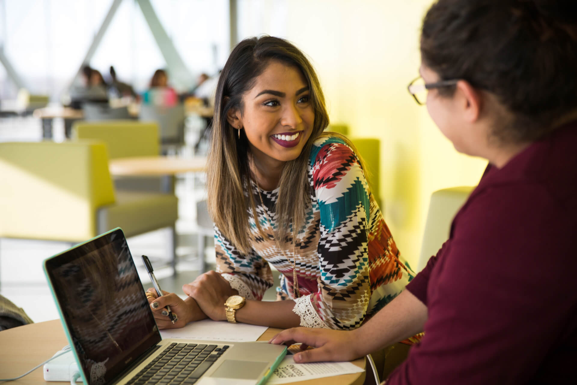 female student smailes at another student as they study in Humber spaces