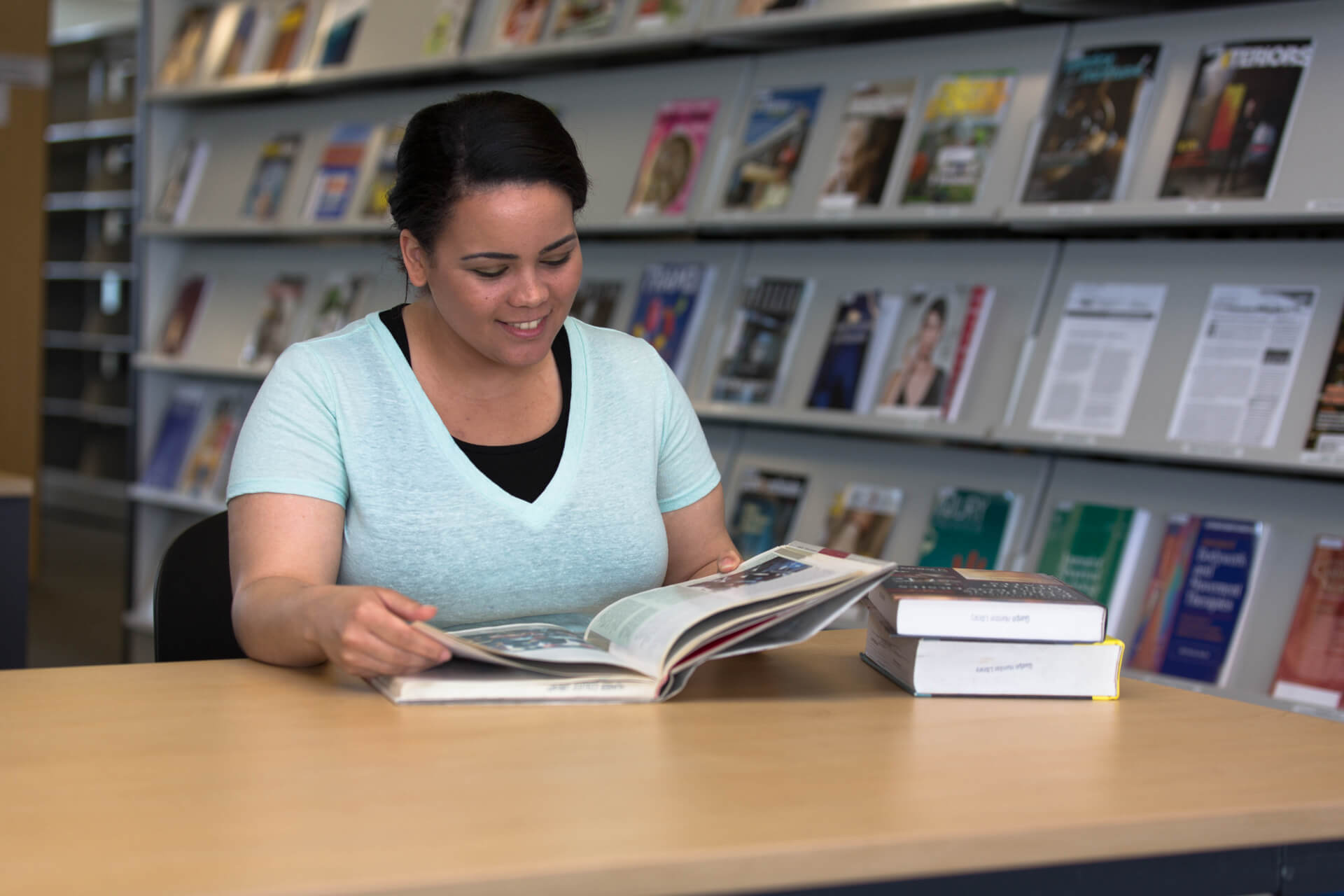 Student flipping through a textbook at the Humber library
