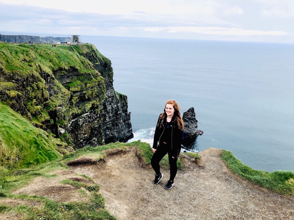 Maegan standing in front of the edge of a cliff