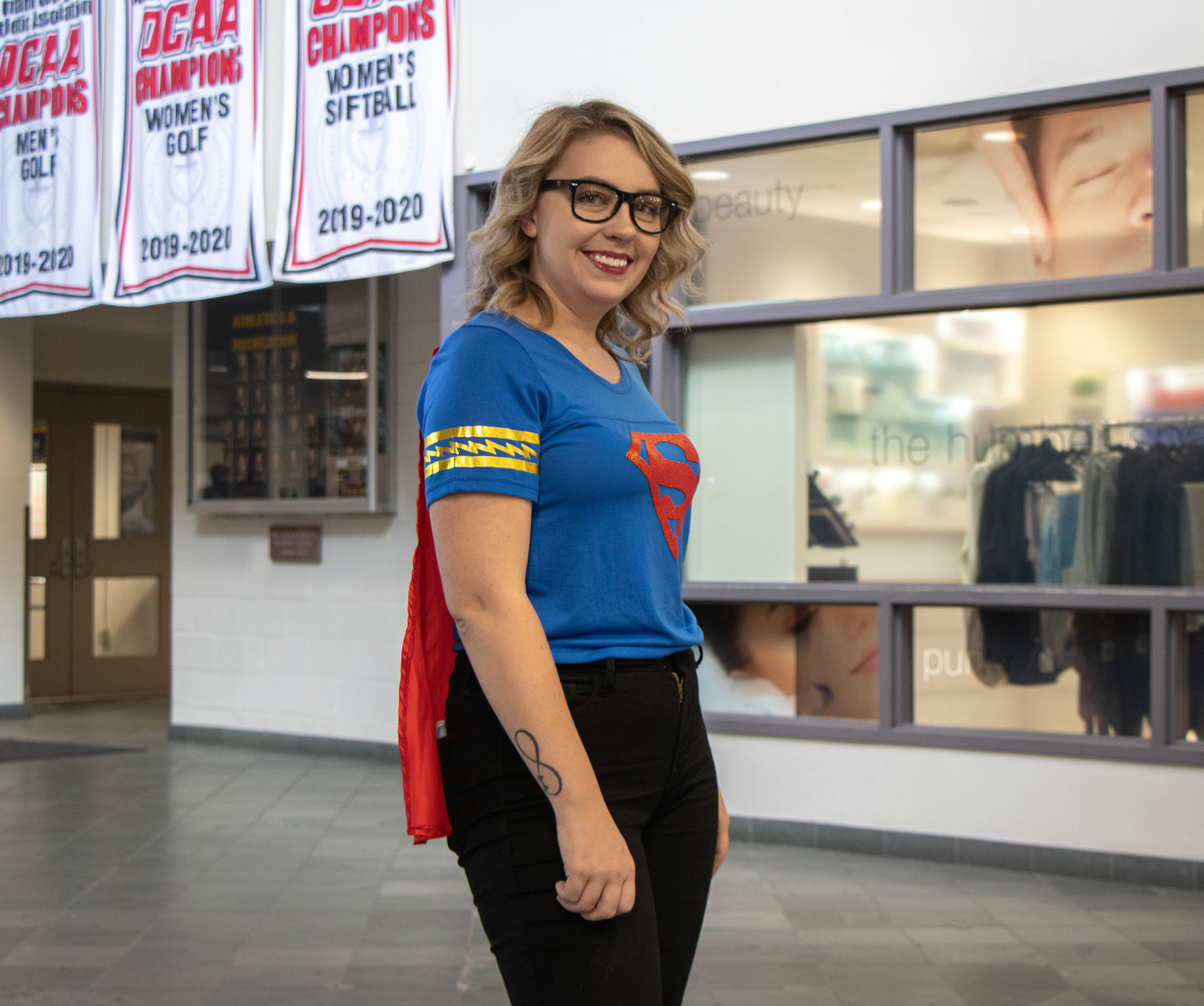 girl wearing superman costume smiles at camera