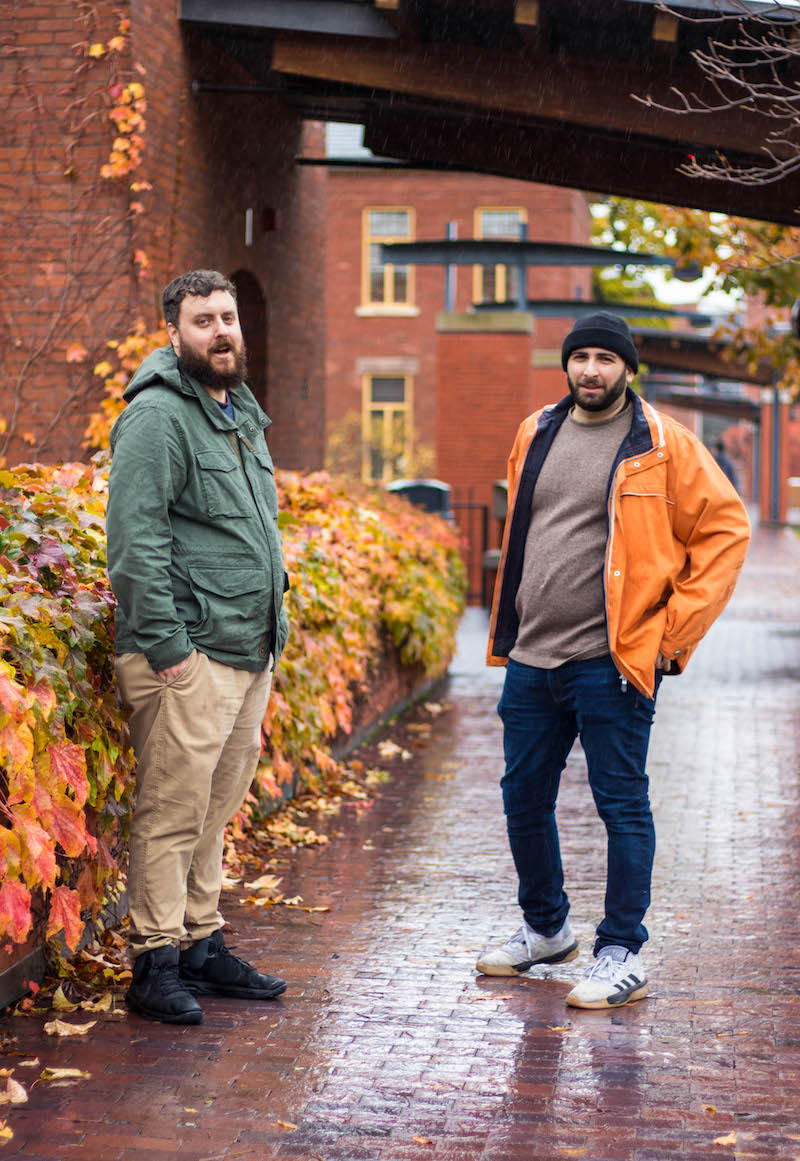 two men standing by wall on rainy day