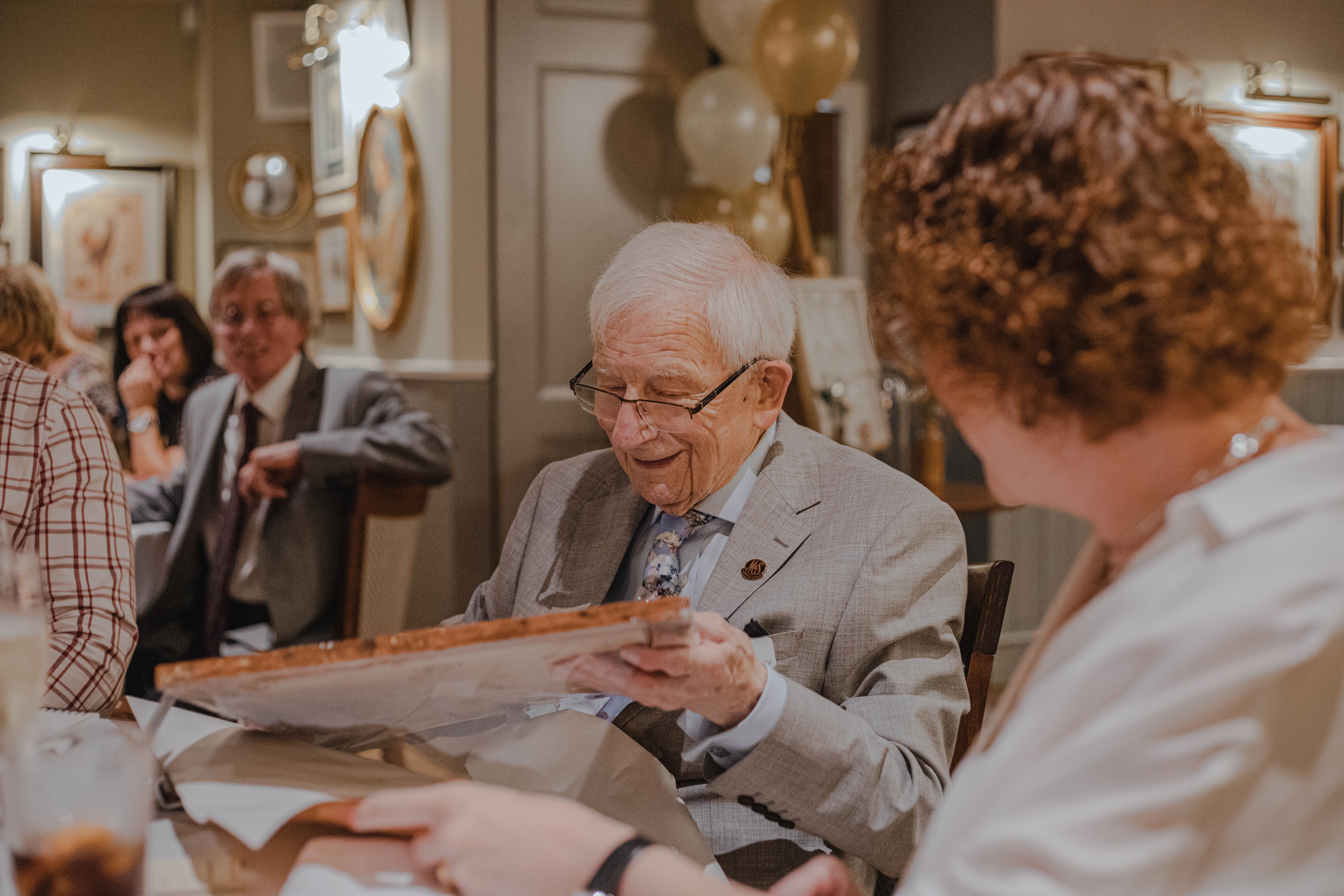 Senior citizen holding a book and smilling