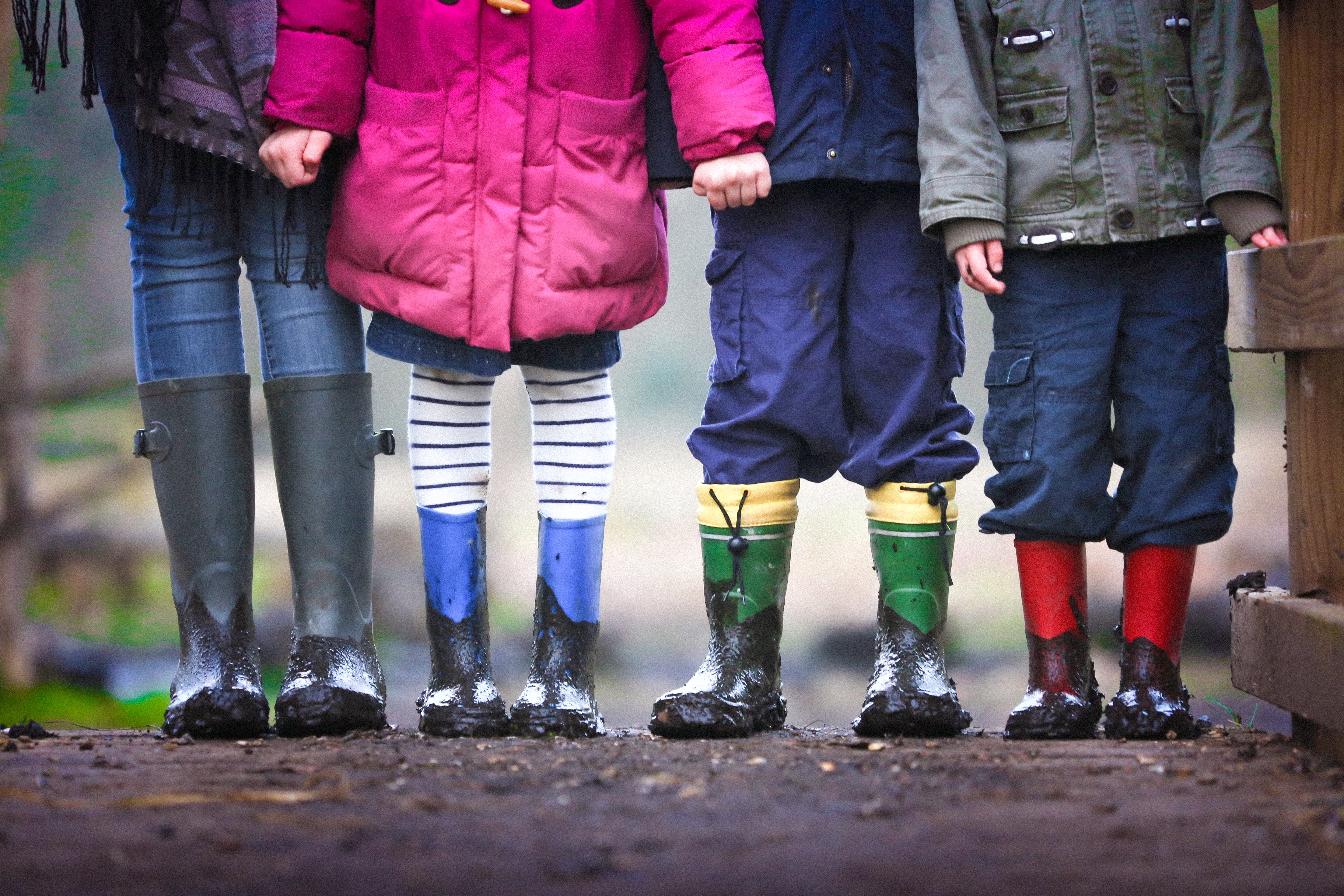 Four children standing in a row holding hands