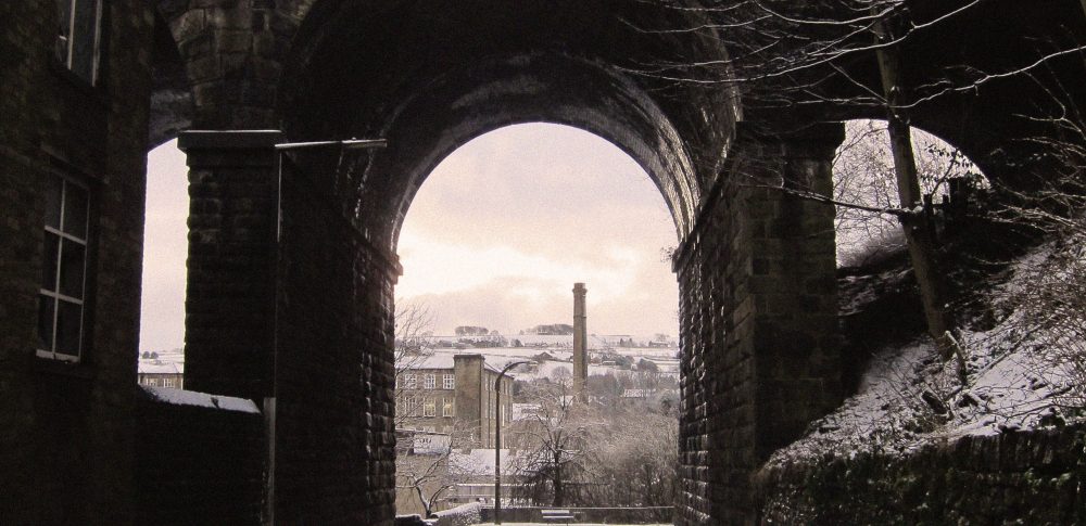 A mill stack seen through an archway