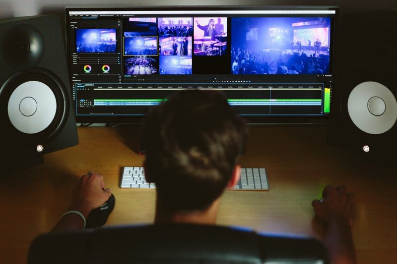 Back of man's head editing video on computer
