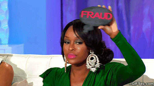 A woman in a green dress holds up a sign that reads, "Fraud."