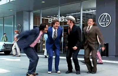 The four newsmen from the movie, "Anchorman," jump joyfully and strike a pose mid-air.