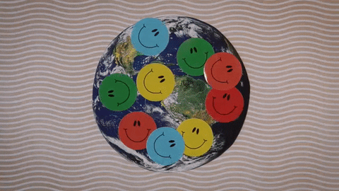 A photo of Earth is covered with yellow, blue, green and red smiley face stickers.