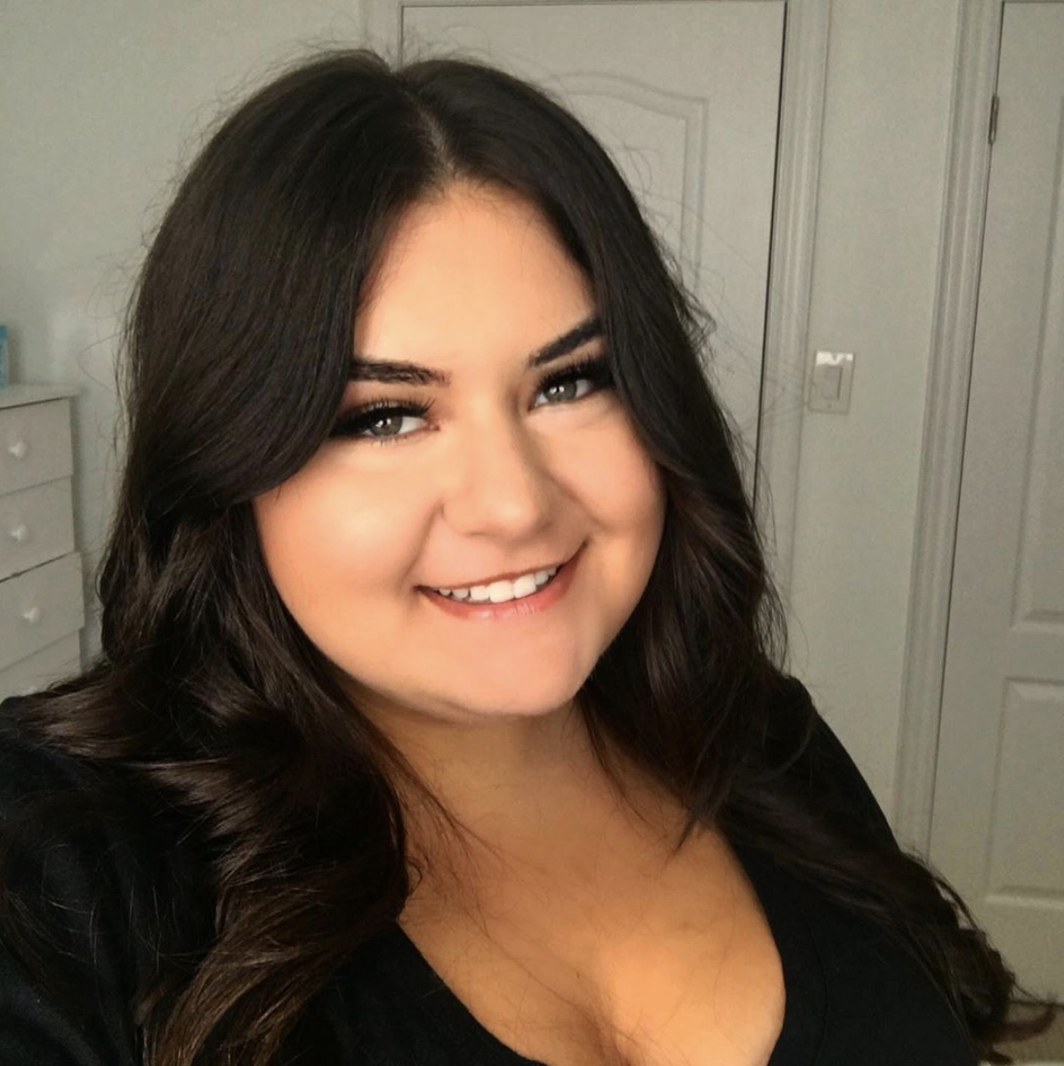 Fourth year University of Guelph-Humber media studies public relations student Cassandra Constantinou smiles at the camera while wearing a black shirt.