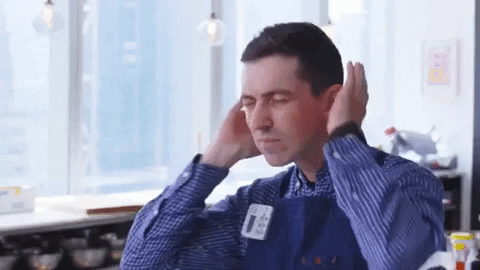 Chef Chris Morocco from the Bon Appetit Test Kitchen mimes wearing headphones and dancing to music.