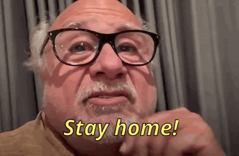 Actor Danny DeVito wears large black glasses and says, "Stay home!"